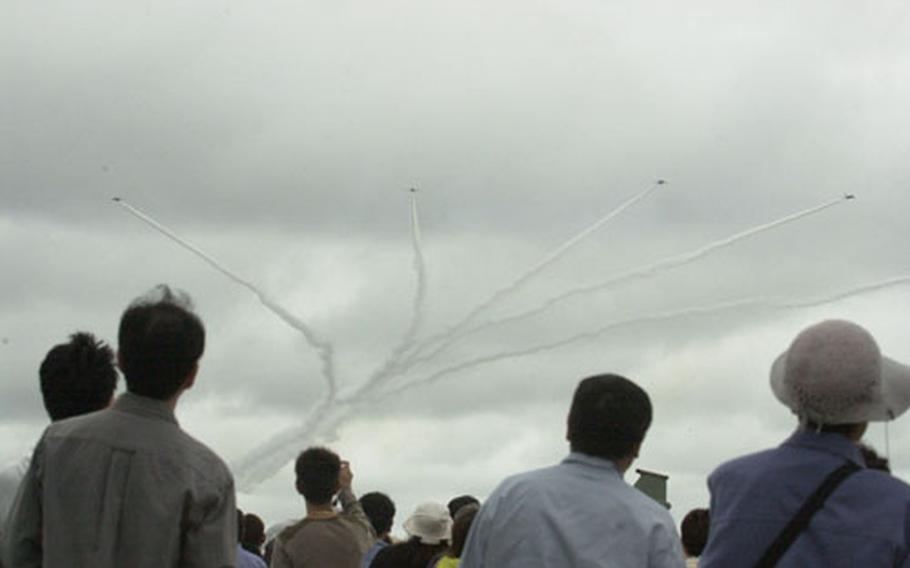 Japanese visitors to Misawa Air Base watch Sunday&#39;s aerial acrobatics of the Blue Impulse Jr. aerial demonstration team.