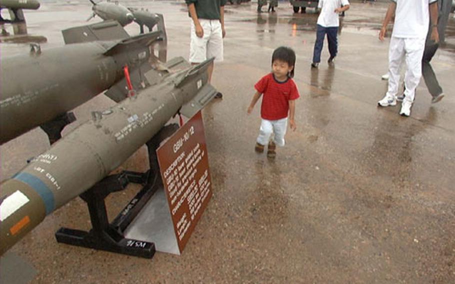 This little guy gets a look at bombs and fighter planes on the flight line at Osan Air Base, South Korea, where bad weather led to cancelling what would have been the second annual Air and Space Power Day air show.