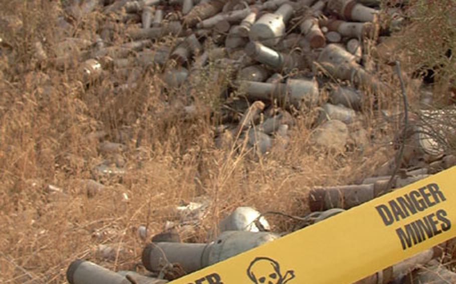 A pile of bomb fuses in a field on Bagram Air Base is marked off by yellow warning tape by explosiveive ordnance disposal teams after the area was cleared by demining dogs.
