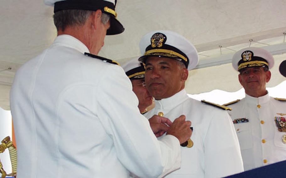 Rear Adm. Michael Holmes, center, receives the Legion of Merit from Adm. Gregory G. Johnson during Holmes’ change of command ceremony Friday at Capodichino in Naples, Italy. Looking on at right is Rear Adm. Stanley Bozin, who relieved Holmes as commander, Fleet Air Mediterranean.