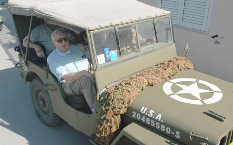 Veteran Joseph Heiser rides in an Italian re-enactor&#39;s jeep through the city of Paestum, Italy, on Tuesday. The Italians have chosen the 36th Infantry Division, of which Heiser was a member during World War II, to model their uniforms and equipment on.