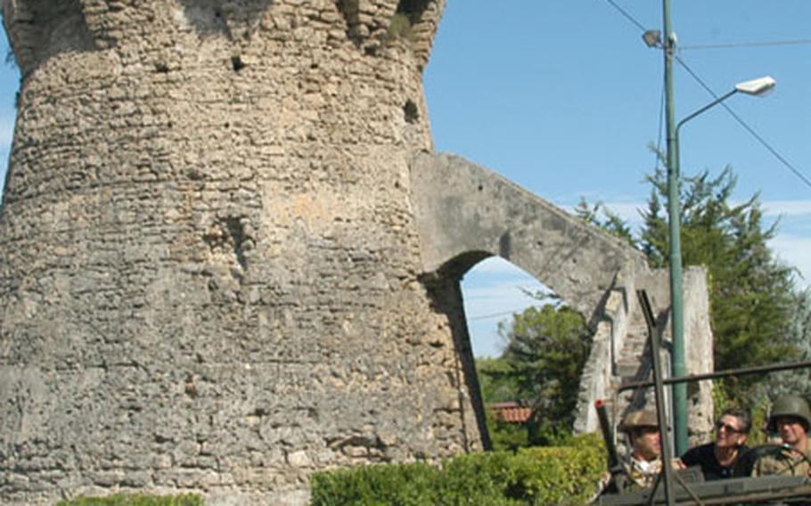 A renovated World War II jeep drives by a Roman tower that was used by German troops as a machine-gun nest during World War II in the Bay of Salerno landings at the town of Paestum, Italy. World War II veteran Joseph Heiser, an infantryman with G Company of the 141st Regiment, 36th Infantry Division, remembered seeing yellow German tracers coming from the tower toward him as he landed in the second wave of the invasion on Sept. 9, 1943.