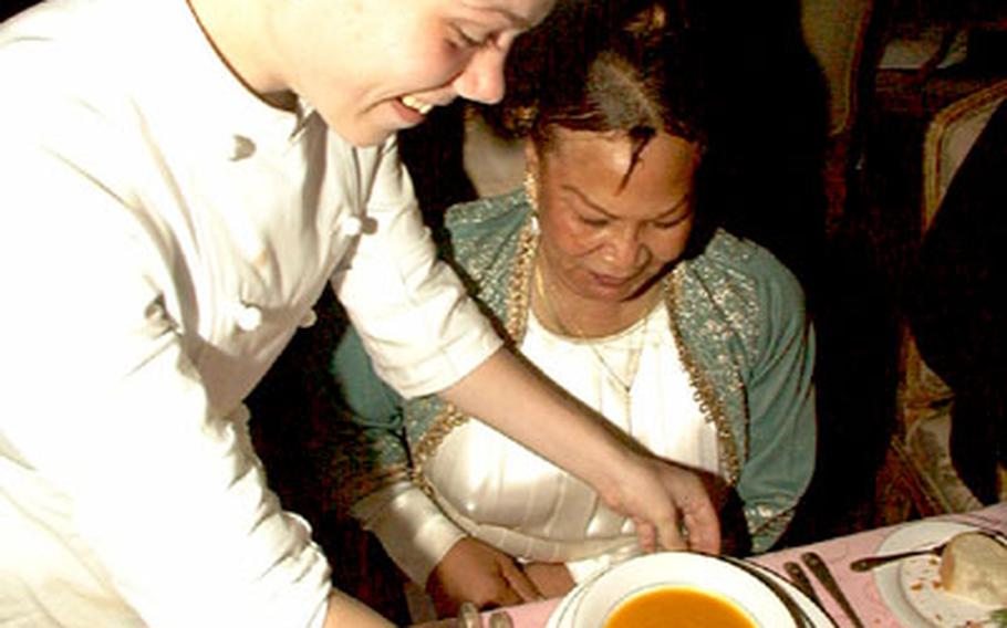 Zama High School senior James Vagasky serves pumpkin bisque to his teacher, Bobbie Donald, one of eight guests invited to dine on a six-course meal prepared by Vagasky at the New Sanno Hotel.