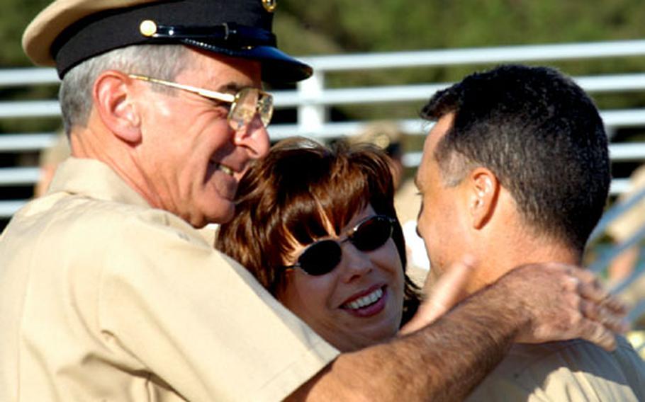 Master Chief Petty Officer Doug Forziati congratulates Chief Petty Officer Mark Anderson after he and Anderson&#39;s wife, Nica, at center, pinned on his anchors Tuesday. Anderson is a musician for the Allied Forces Southern Europe band, and Forziati is the senior enlisted member of the unit.