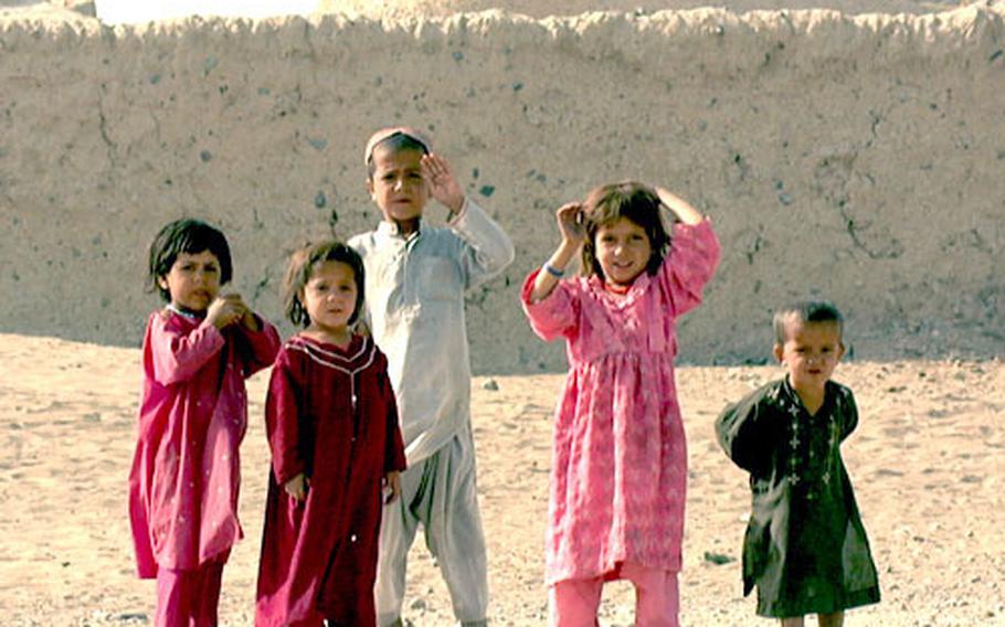 Children from the Afghan village of Mir Afdzai Kalay wave at civil affairs and psychological operations soldiers Monday.