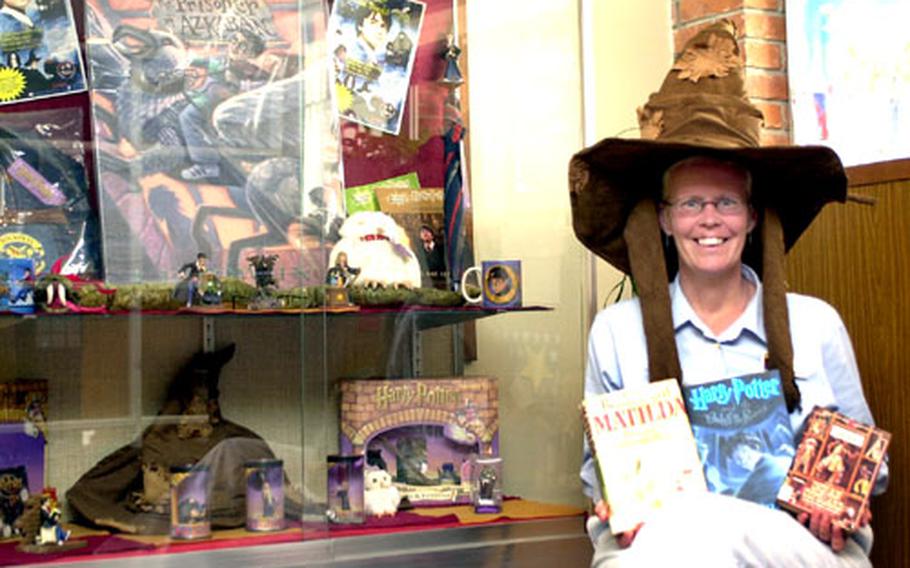 Cindy Tews, Kadena Base Library director, wears a Sorting Hat from the popular Harry Potter series and holds one of the books, along with several others on the 100 Most Frequently Challenged Books list.