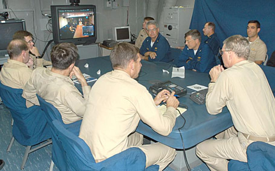 Vice Admiral Gary Roughead, Commander, Second Fleet/NATO Striking Fleet Atlantic and members of his staff conduct a Video Teleconference (VTC) from the USS Bataan (LHD 5) Wednesday. A portion of the Second Fleet/Striking Fleet staff embarked USS Bataan, and got underway on Tuesday to avoid Hurricane Isabel. The amphibious assault ship, which is serving as the Second Fleet flagship, sortied with about 40 other Navy ships from the Hampton Roads area.