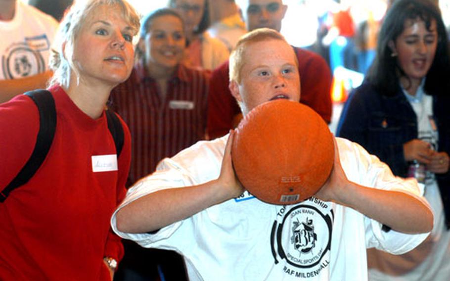 Master Sgt. Allison Lister, left, watches as Gavin Hamilton, 16, prepares to shoot a basketball Saturday during Joan Mann Sports Day at RAF Mildenhall, England. Lister was one of 600 volunteers and Hamilton was one of 200 athletes at the special day.