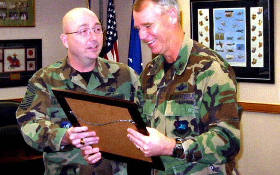 Chief Master Sgt. Thomas Langdon, left, with his boss, Brig. Gen. William Holland, who commands the Air Force&#39;s 51st Fighter Wing at Osan Air Base, South Korea, as they look over a plaque given the general at a recent ceremony. Langdon, the wing&#39;s Command Chief Master Sergeant and Holland&#39;s top enlisted adviser, ends his Osan later this month and moves to Misawa Air Base, Japan.