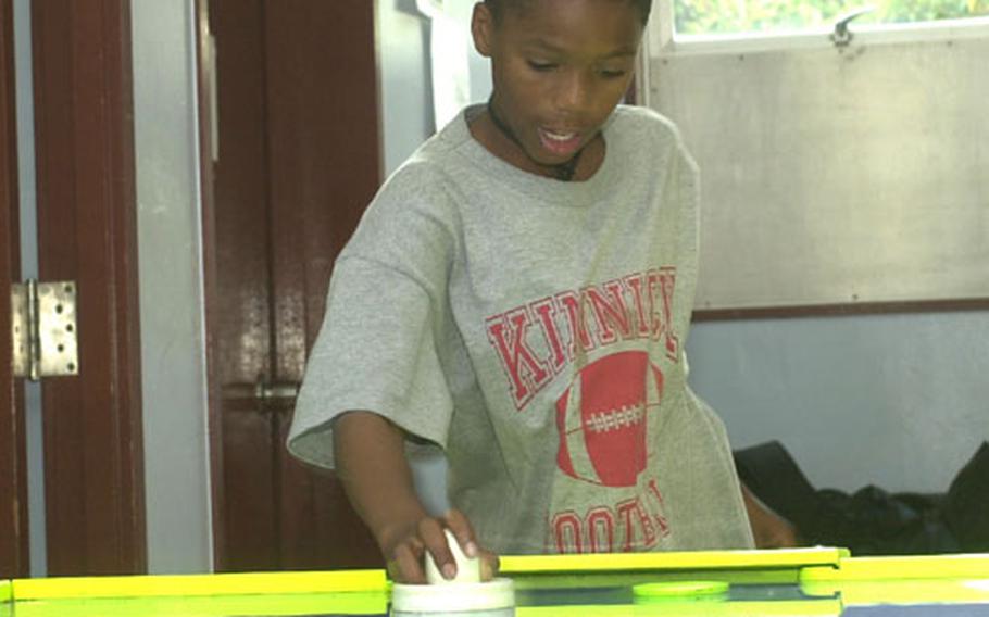 Richard Barton, 12, plays air hockey after school at the Yokosuka Teen Center. His father is assigned to the USS Kitty Hawk. The center, near the middle and high schools, offers teens pool tables, air hockey, foozball and computers.