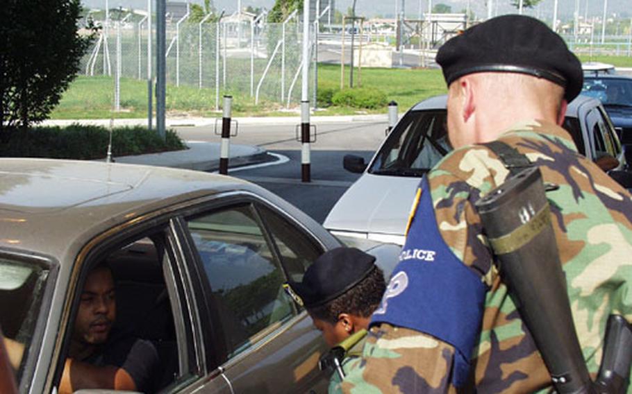 A Minnesota National Guardsman, wearing an armband to show his affiliation with the Air Force, checks out a motorist passing through the gate at Aviano Air Base in Italy. The part-time soldiers are spending the next six months on active duty in Europe, guarding gates at bases in the United Kingdom, Belgium, Germany, Italy and Turkey.