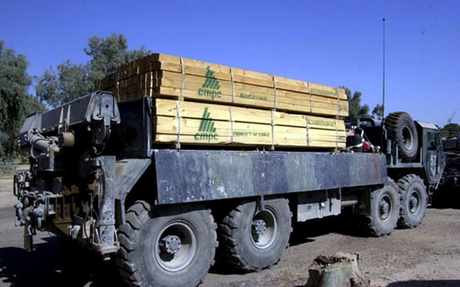 A military transport truck loaded with Chilean lumber sits at an Army base in Baghdad.