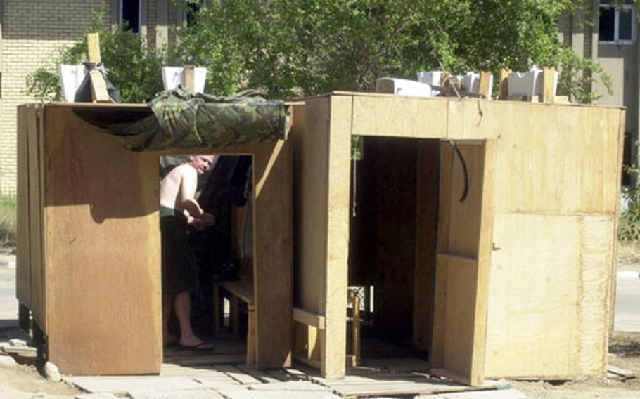 Troops are using wood for everything from tent floors to showers, such as this one at a base in downtown Baghdad.