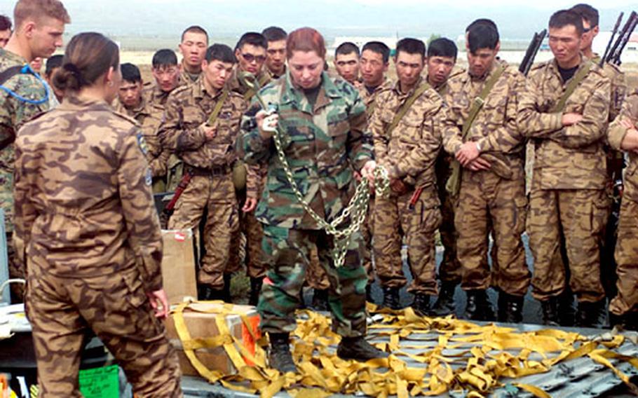 Staff Sgt. Marylyn Sabol, shows Mongolian troops the proper way to load a pallet.