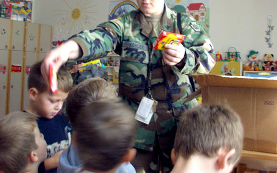 Sgt. Desiree Kohler of the 628th Finance Detachment hands out boxes of crayons at the Our Future day care in Urosevac.