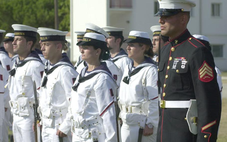A U.S. Marine stands next to a group of Spanish Navy sailors Thursday at Naval Station Rota, Spain. The United States and Spain celebrated the 50th anniversary of a historic defense pact that allowed the basing of American troops in Spain.