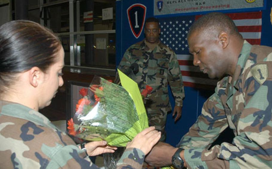 First Lt. Rosemary Reed and Staff Sgt. Tony Jordan of the Army&#39;s 64th Replacement Company at Rhein-Main Air Base, Germany, prepare flowers for the arrival of the first soldiers returning from Iraq on two weeks of leave. In the background is 1st Sgt. Willie Lemons.