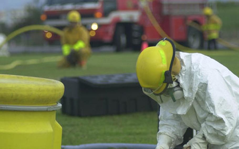 A Torii Station firefighter gets ready to clean up a simulated fuel spill with an absorbing material during the base&#39;s annual mass casualty exercise Sept. 26. In addition to the "fuel spill," there was a four-vehicle "accident" and a "helicopter crash."