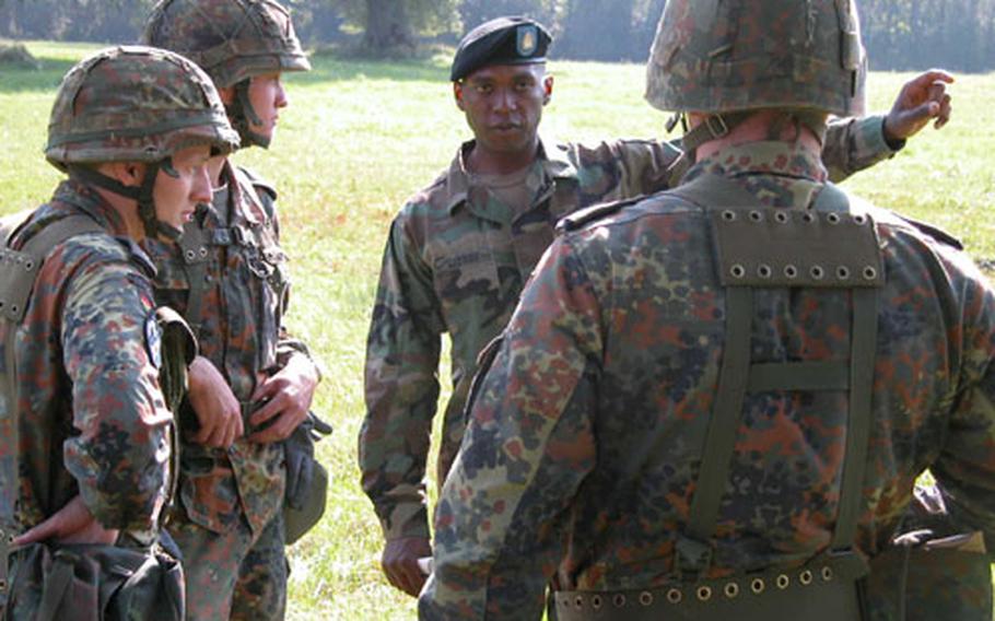 U.S. Army Spc. Reggie Gadson of the 401st Military Intelligence Company at Bad Aibling gives instructions to German soldiers prior to the land navigation contest Sept. 21 at the International Military Skills Competition in Brannenburg, Germany.