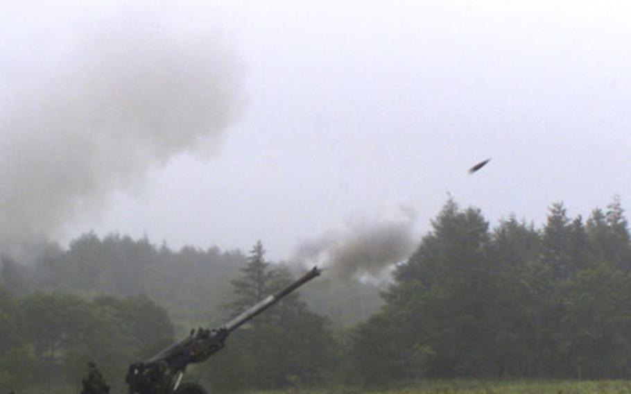 An explosive round flies out of an M198 155mm medium howitzer at the Yausubetsu Maneuvering Area, Hokkaido, Japan.