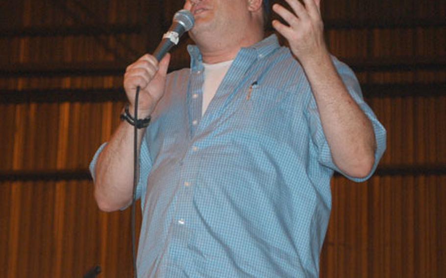 Comedian Drew Carey performs for a mostly 1st Armored Division crowd Saturday night in a hangar at Baghdad International Airport. He and six other comedians, including Drew Carey Show co-star Kathy Kinney, did three shows in Iraq, including two in Baghdad and one in Tikrit for 4th Infantry Division personnel.