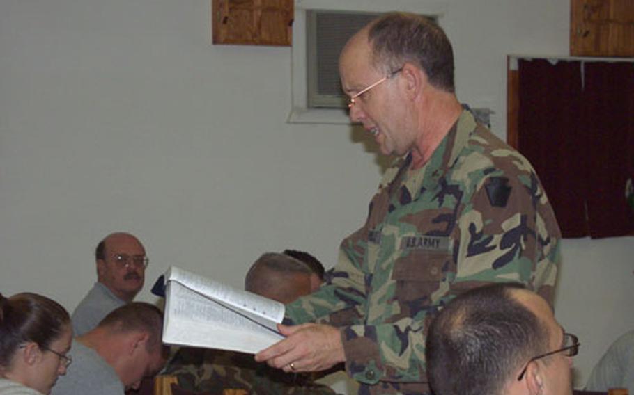 Chaplain (Maj.) Bruce David Farrell, of the 28th Infantry Division, Division Artillery, reads a verse out of the Bible Wednesday in a chapel on Camp Bondsteel, Kosovo. The verse related to a 25-minute historical video on the odyssey of the apostle Paul. Students must attend eight classes in order to go on a retreat following in Paul&#39;s footsteps through Greece.