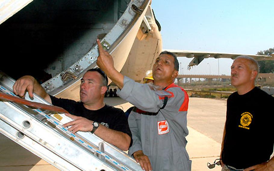 Staff Sgt. Clem McLaughlin, left, and Raad al-Khalil call out instructions to Iraqi firefighters in the cargo compartment of an Iraqi Airways jet at Baghdad International Airport. The firefighters are going through 10 days of refresher training taught by McLaughlin and Master Sgt. John Mallott, right.
