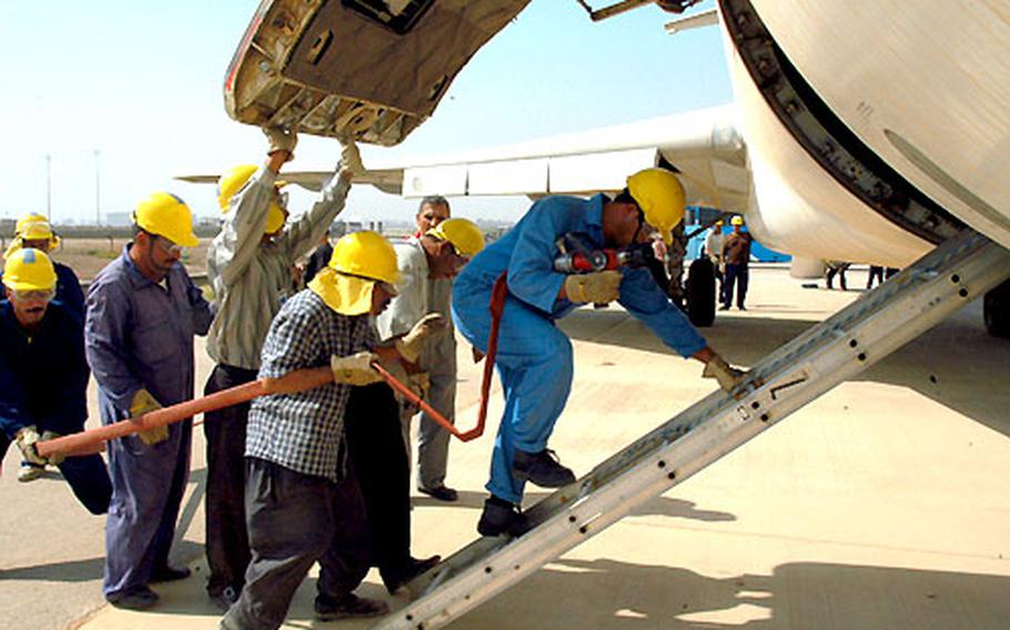 Iraqi teams enter the cargo hold of an abandoned Iraqi Airways jet at Baghdad International Airport as part of their firefighting training. Another team of firefighters went into the passenger compartment to practice checking for passengers and crew who might be trapped or hurt by the fire or smoke.