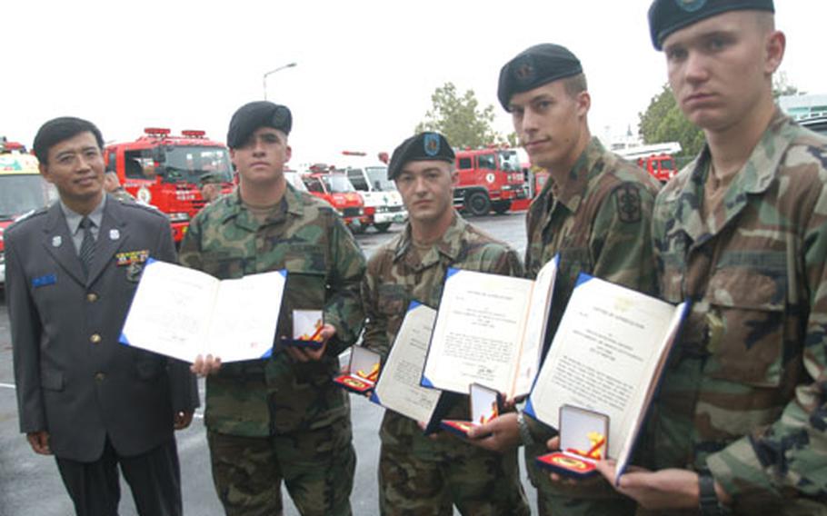 Four soldiers were recognized Wednesday by the Yongsan Fire Station for aiding an injured moped rider Aug. 29 near Itaewon. From left: Yongsan Fire Station Administrator Choi Duk-ki, Cpl. Todd Crow, Pfc. William Dreibelbis, Pvt. Jason Burnette and Pvt. Zbigniew Rutkowski.