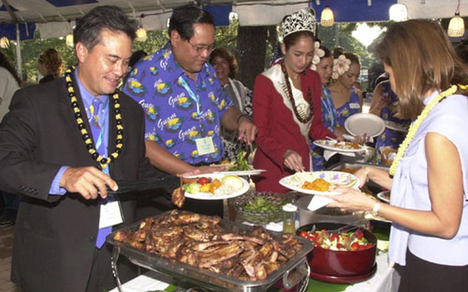Felix Camacho, Governor of Guam, places some traditional Chamorran food on his plate during a visit to Camp Zama&#39;s Dewey park, Thursday. Camacho, visited with Kanto Plain servicemembers from Guam while returning from a Pacific tour promoting tourism to Guam.