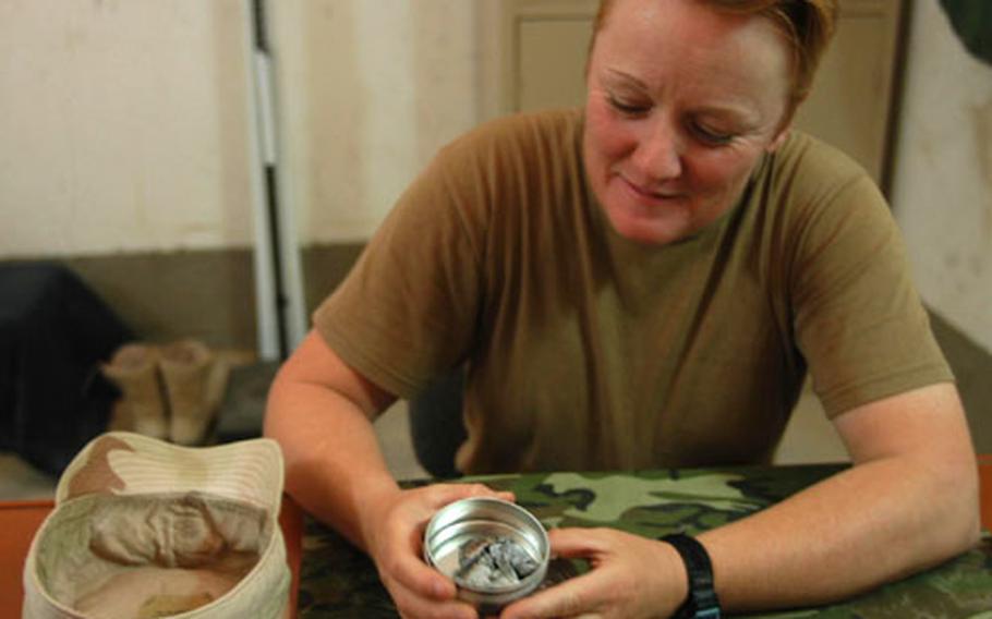 Battalion Command Sgt. Major. Vaneta Vaughn shows an Altoids tin holding mortar fragments from attacks on Logistics Base Seitz. The small pile of fragments is indicative of the number of times they&#39;ve been mortared; she takes one fragment from each attack.