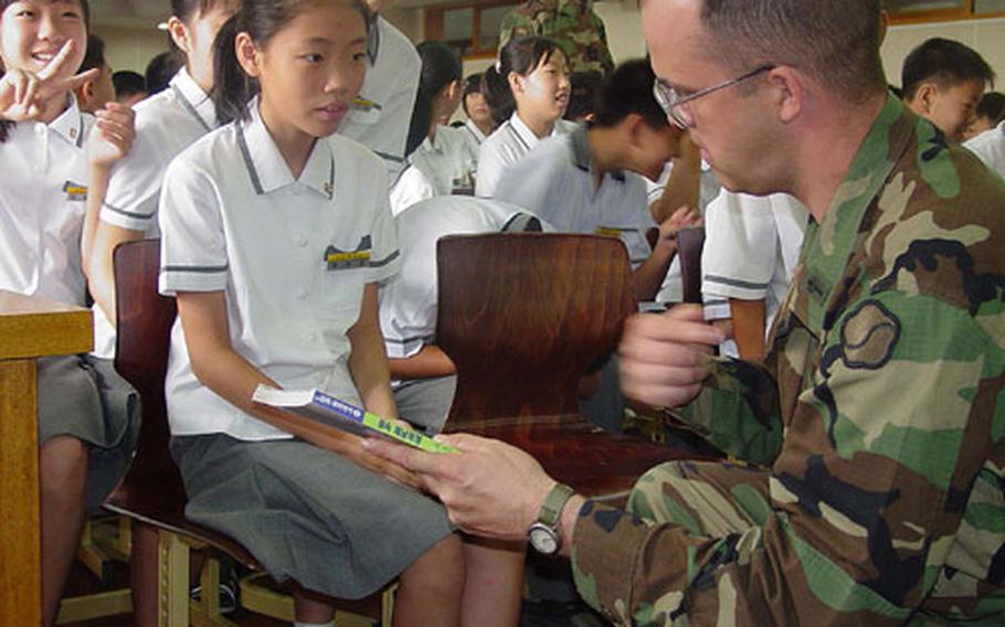 Capt. Ralph L. Bieganek, 23rd Chemical Battalion chaplain, chats with Kwon Su-jin at Seok Jeon Middle School in Waegwan, South Korea. Soldiers from the battalion are to teach the students English - and perhaps slip in some American history and culture lessons as well.