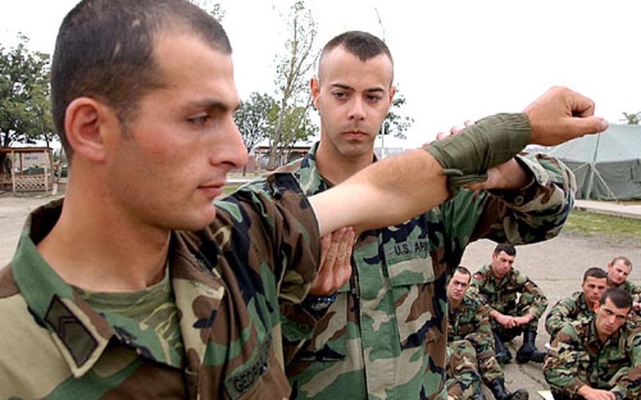 Army Spc. David Becker, a medic with the 67th Combat Surgical Hospital from Würzburg, Germany, shows Georgian soldiers how to apply a dressing to a wound. Becker is part of a medical unit training new Georgian soldiers in Georgia Train and Equip, a U.S. European Command operation.
