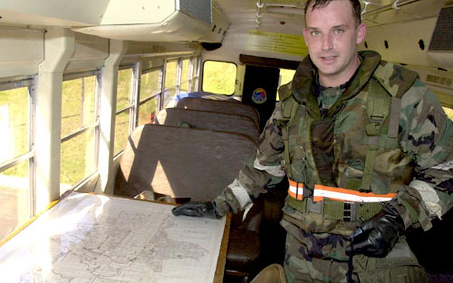 Tech. Sgt. Robert Petermann, his face dripping with sweat after removing his chemical mask, stands in the vehicle management flight&#39;s mobile command post, where maps, phone numbers, keys and tools are stored.