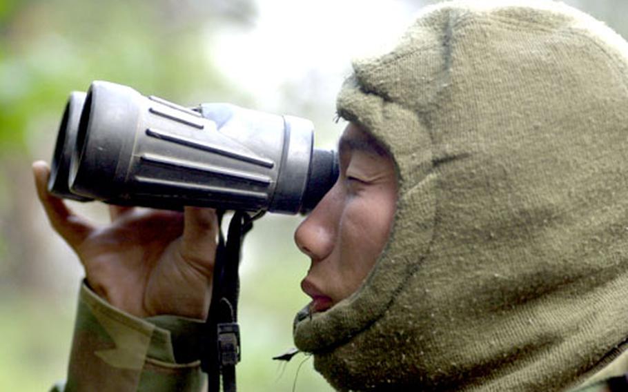 Sgt. S.K. Lee, a South Korean augmentee assigned to Company B, 2/72 Armor, scans for enemy scouts during battle training in the Strike ARTEP exercise.
