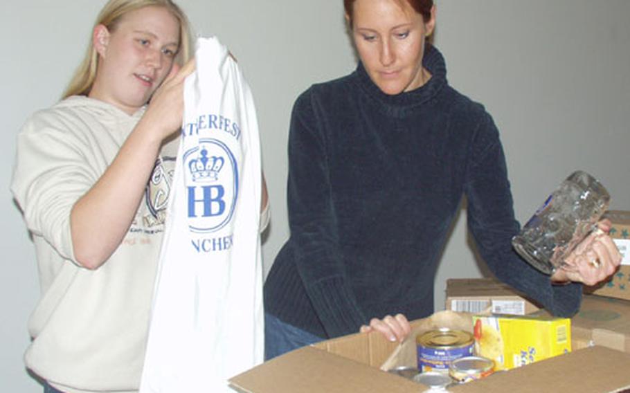 Katharina Lowe, left, and Sofia Caulwell, package up a box of food and Oktoberfest mugs and T-shirts to send to the troops of Company B, 2nd Battalion, 37th Armored Division from Friedberg, Germany.