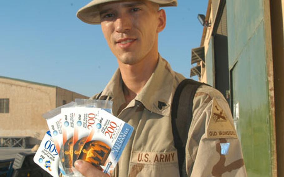 Sgt. William Bernal of the 47th Forward Support Battalion holds up the stack of phone cards he carries with him in case he has the opportunity to call his wife in Germany or family in the United States. Bernal&#39;s family sends him either Wal-Mart or Sam&#39;s Club phone cards from home and he also purchases cards from the Baghdad International Airport exchange. He gets more talk time per dollar from the AAFES cards.