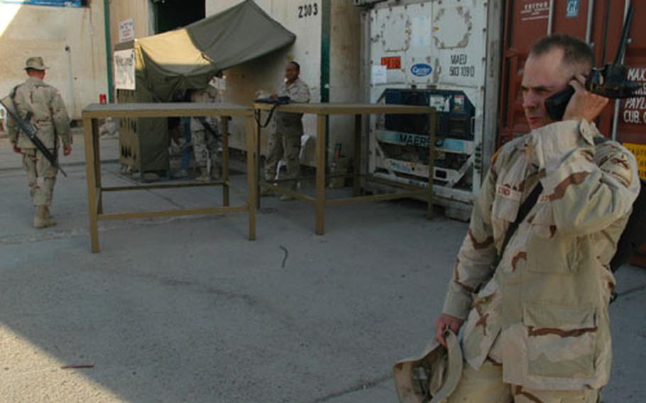 Sgt. Monty Lynch of the 1st Battalion, 501st Aviation Regiment, uses a satellite telephone outside the Baghdad International Airport AAFES exchange main entrance. Military members are able to use the phones, which are available from the small tent at left.