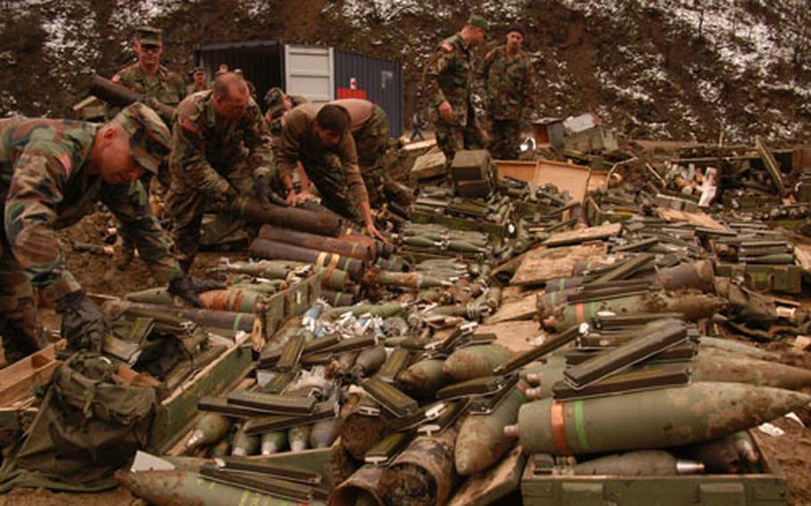 U.S. soldiers layer ammunitions and C-4 explosives so that they can be destroyed in a big explosion on Thursday at Velika Ribnica demolition range in Bosnia and Herzegovina. The munitions come from Bosnian weapons storage sites that have been closed as part of the Bosnian armed forces reductions. The range is the only one in multinational Brigade North that is remote enough from local communities to permit large amounts of ammunition to be destroyed.