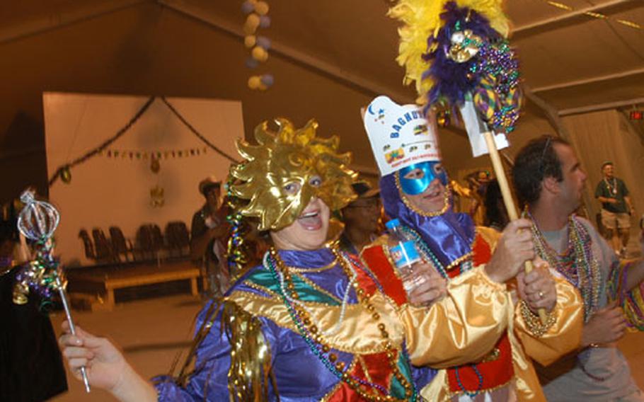 Krewe of Baghdad vice president Senior Airman Tracie Sowels, left, Baghdaddy-O (Chaplain (Maj.)) Paul Sherouse and an unidentified partygoer dance at the Baghdad Mardi Gras ball on Camp Sather at Baghdad International Airport last Friday.