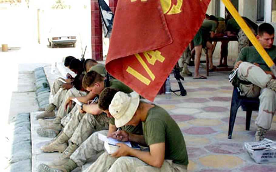 Marines from the 1st Battalion, 4th Marines of the 1st Marine Division fill out survey forms at Camp Twin Towers, a former headquarters for the Baath Party.