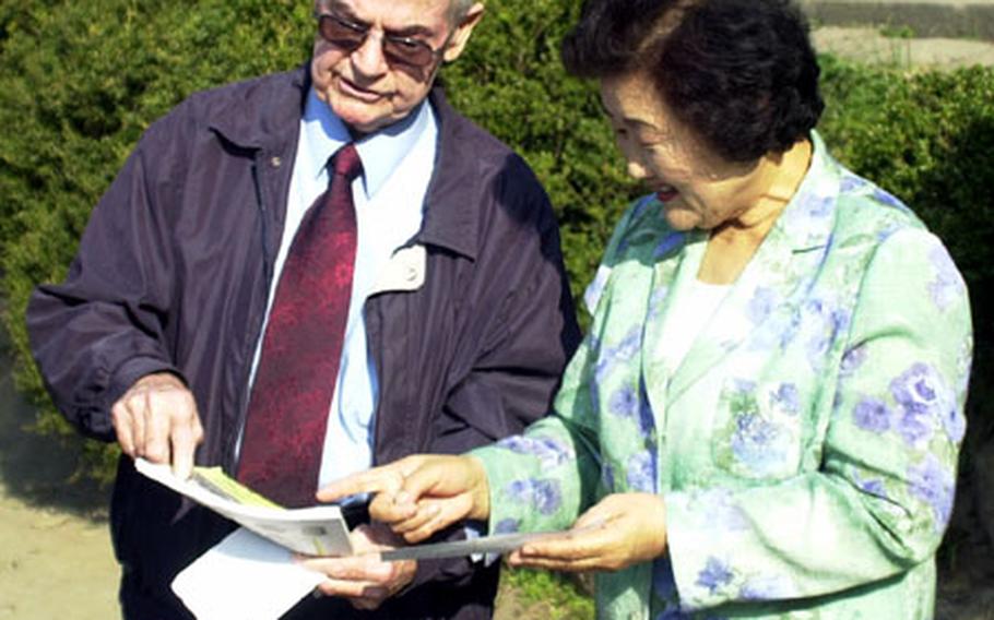 Curley Knepp, a Korean War veteran, gives a $5,000 check Thursday to Kim Jong-won, director of the Sam Dong Boys Town orphanage.
