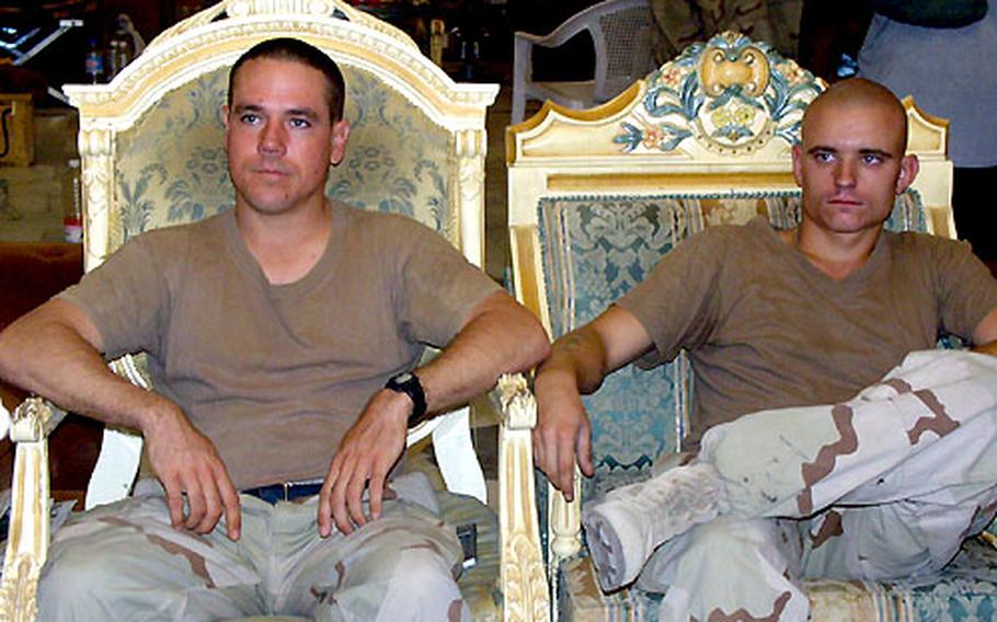 Two soldiers from the 1st Armored Division relax and watch TV at one of Odai Hussein&#39;s former palaces in Baghdad.
