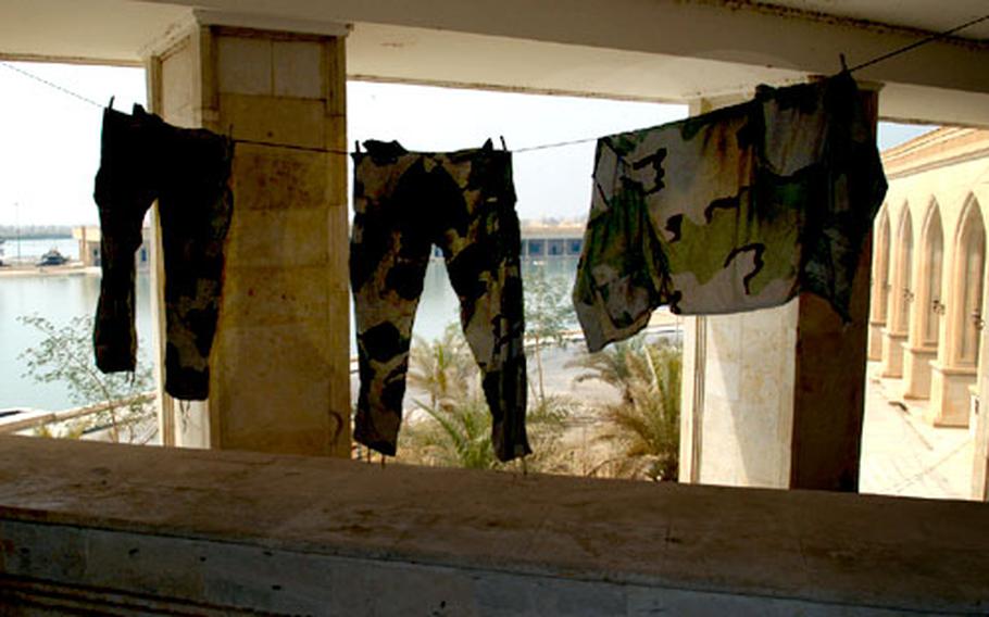 BDUs hang from a second-floor balcony at the Al Faw palace on Camp Victory near Baghdad International Airport. The palace is surrounded by a man-made lake.