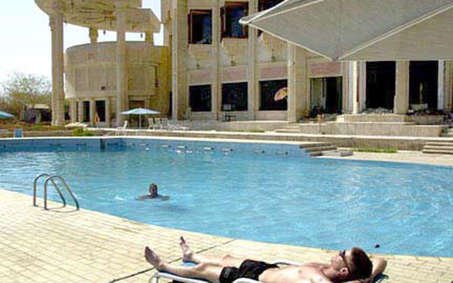 1st Armored Division soldiers at Odai Hussein’s palace in Baghdad, Iraq, kick back in a swimming pool at the complex.