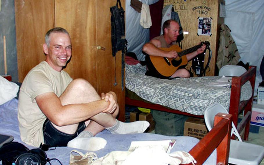 Staff Sgt. David Barnett, foreground, and Staff Sgt. Scott Davis relax in their air-conditioned tent at Tallil Air Base near Nasiriyah, Iraq. The airmen from the 215th Engineering Installation Squadron, a National Guard unit from Everett, Wash., have added carpets, a large refrigerator and a television to make their living quarters more homey.