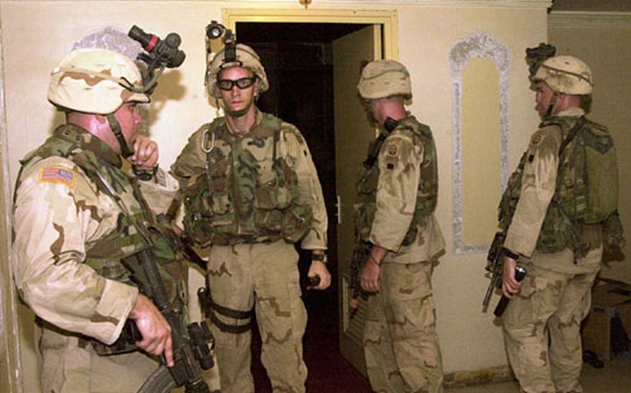 Soldiers with the 82nd Airborne Division wait for additional orders after searching a home in Baghdad, Iraq, after an August raid.