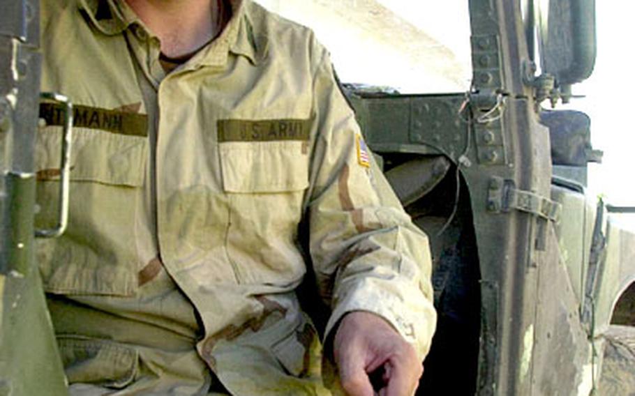 Capt. Ned Ritzmann holds a sharp slice of shrapnel that narrowly missed killing him after slicing into his Humvee recently.