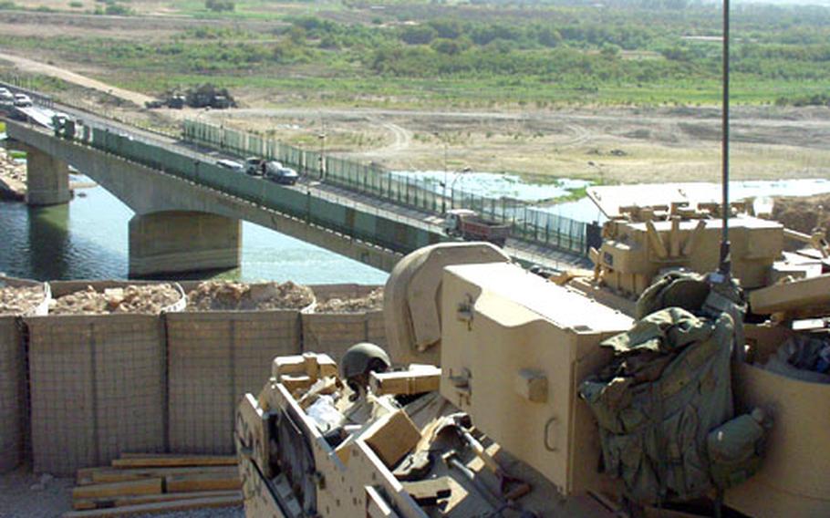 A Bradley Fighting Vehicle looks over a nearby bridge outside of Tikrit, Iraq. Plans are in place to vastly improve the living conditions in Iraq, but troops still have concerns.