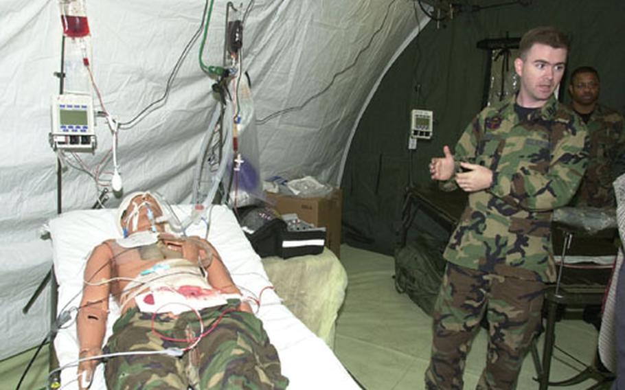 Capt. Richard Tyson, an internal medicine doctor at Yokota Air Base, demonstrates the use of a portable ventilator with a mannequin.